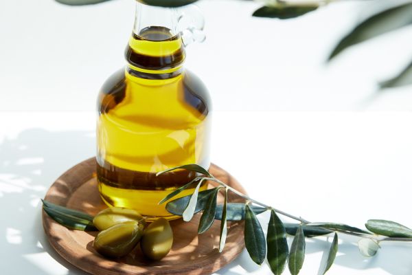 Olivenöl mit Oliven und Olivenzweig