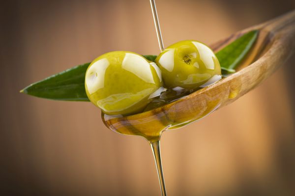 Oliven mit Olivenöl auf Holzlöffel